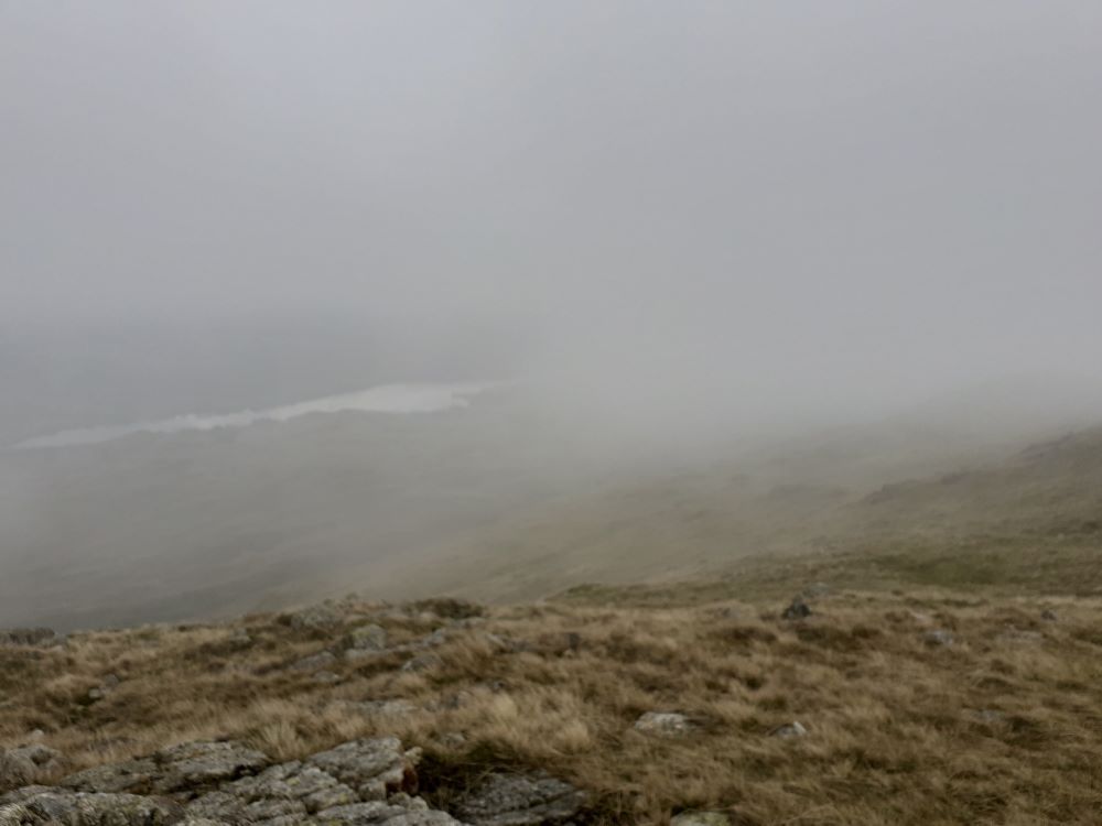 View of Coniston Water from the top of Wetherlam, clouded by mist