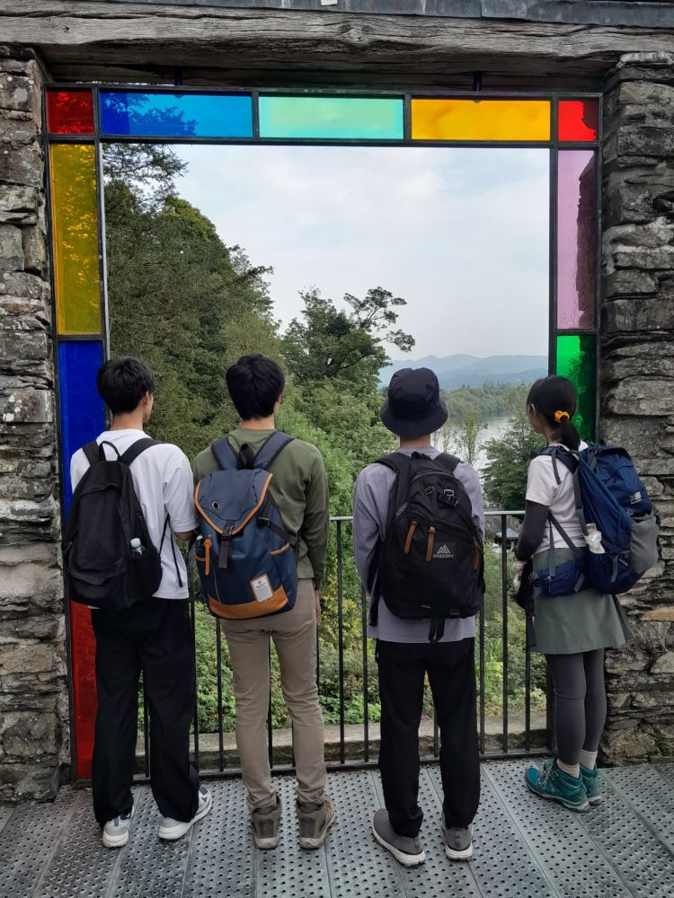 Students gazing through a window at a view of Windermere